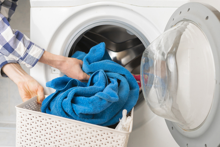 https://www.merrymaids.com/images/articles/Person-s-hand-put-dirty-clothes-in-the-washing-machine-Merry-Maids.jpg